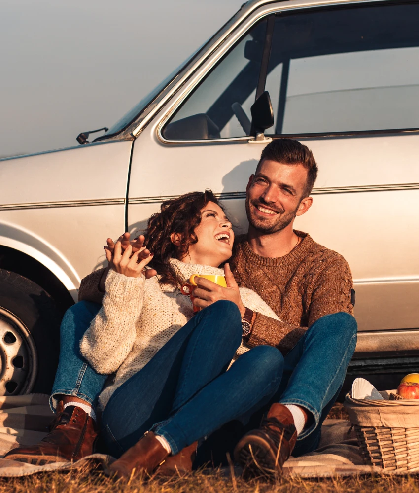 un couple heureux partage un pique-nique en bordure de route montrant de petites choses qui les maintiennent ensemble