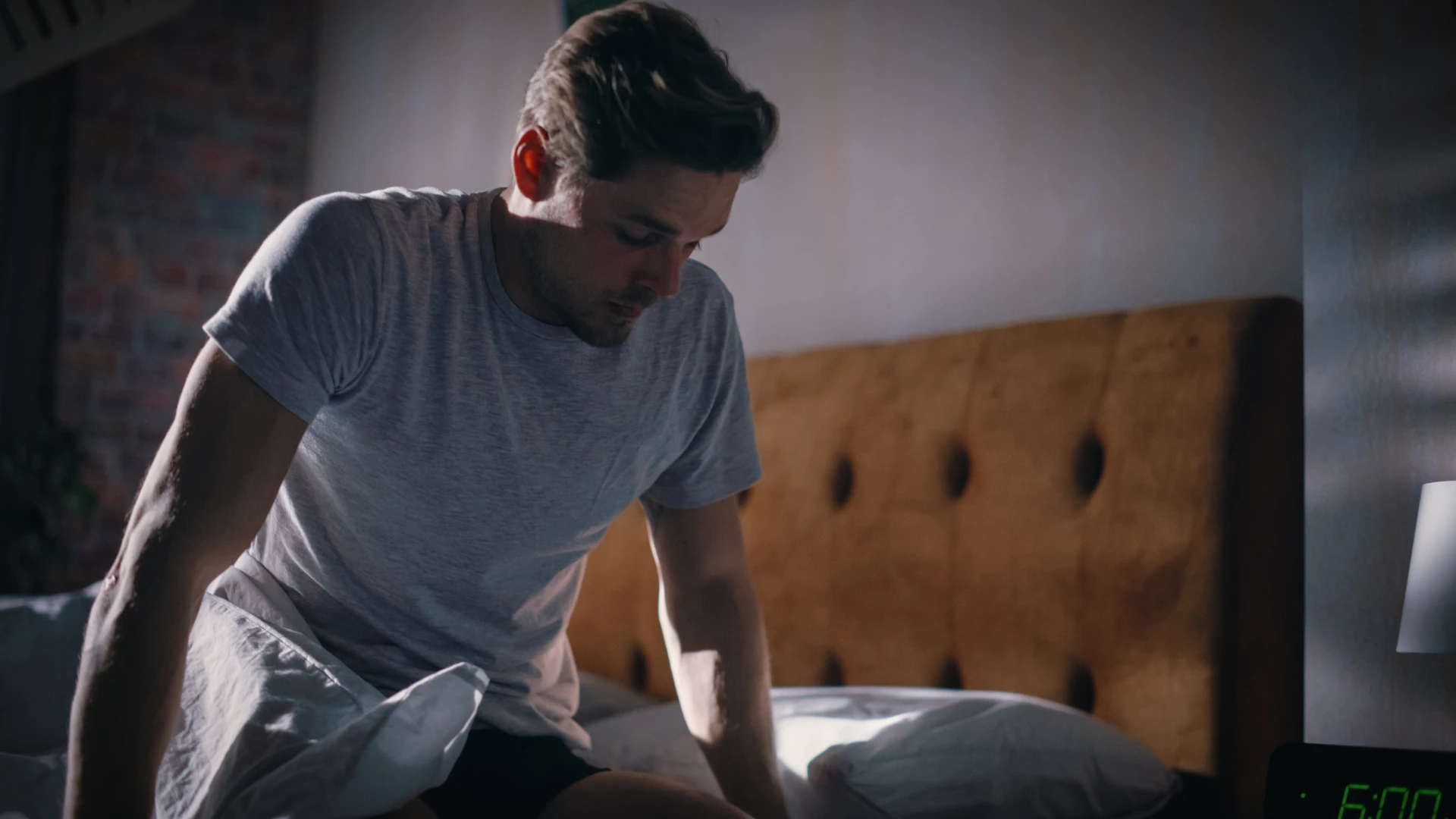 homme bouleversé assis sur le bord du lit