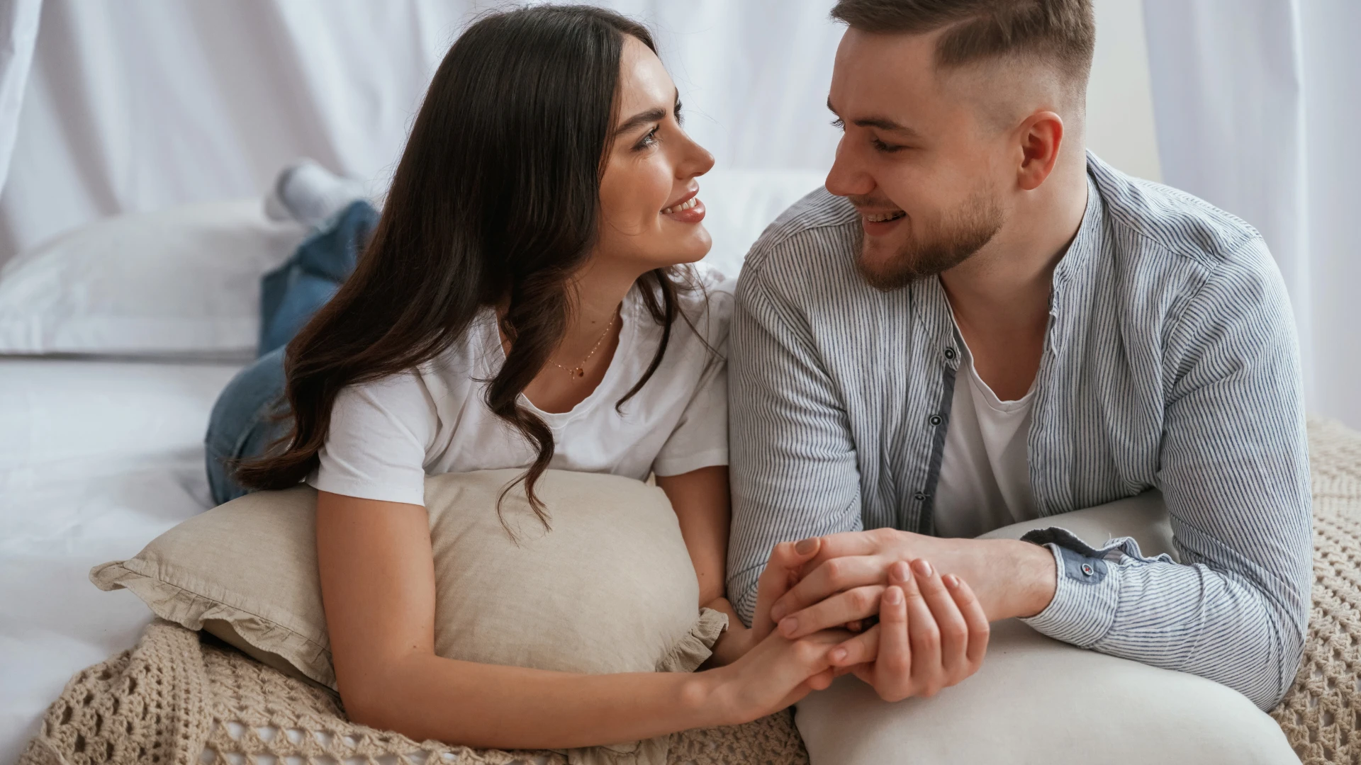 couple ayant une conversation en position couchée sur le lit