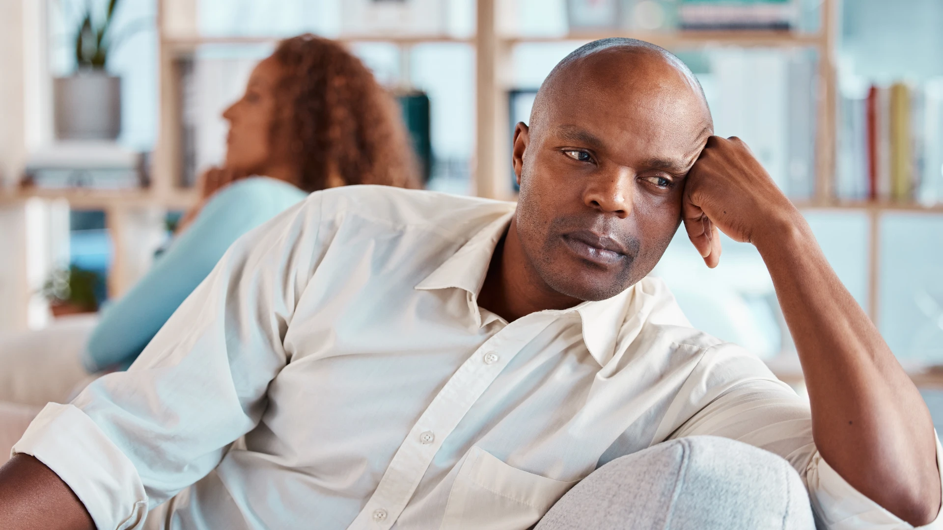 homme bouleversé assis loin de sa femme