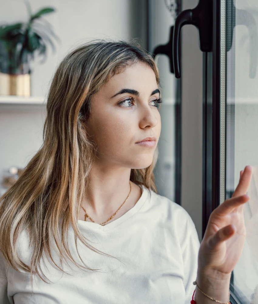 Une femme suspecte regarde par la fenêtre et montre que son partenaire va probablement tricher