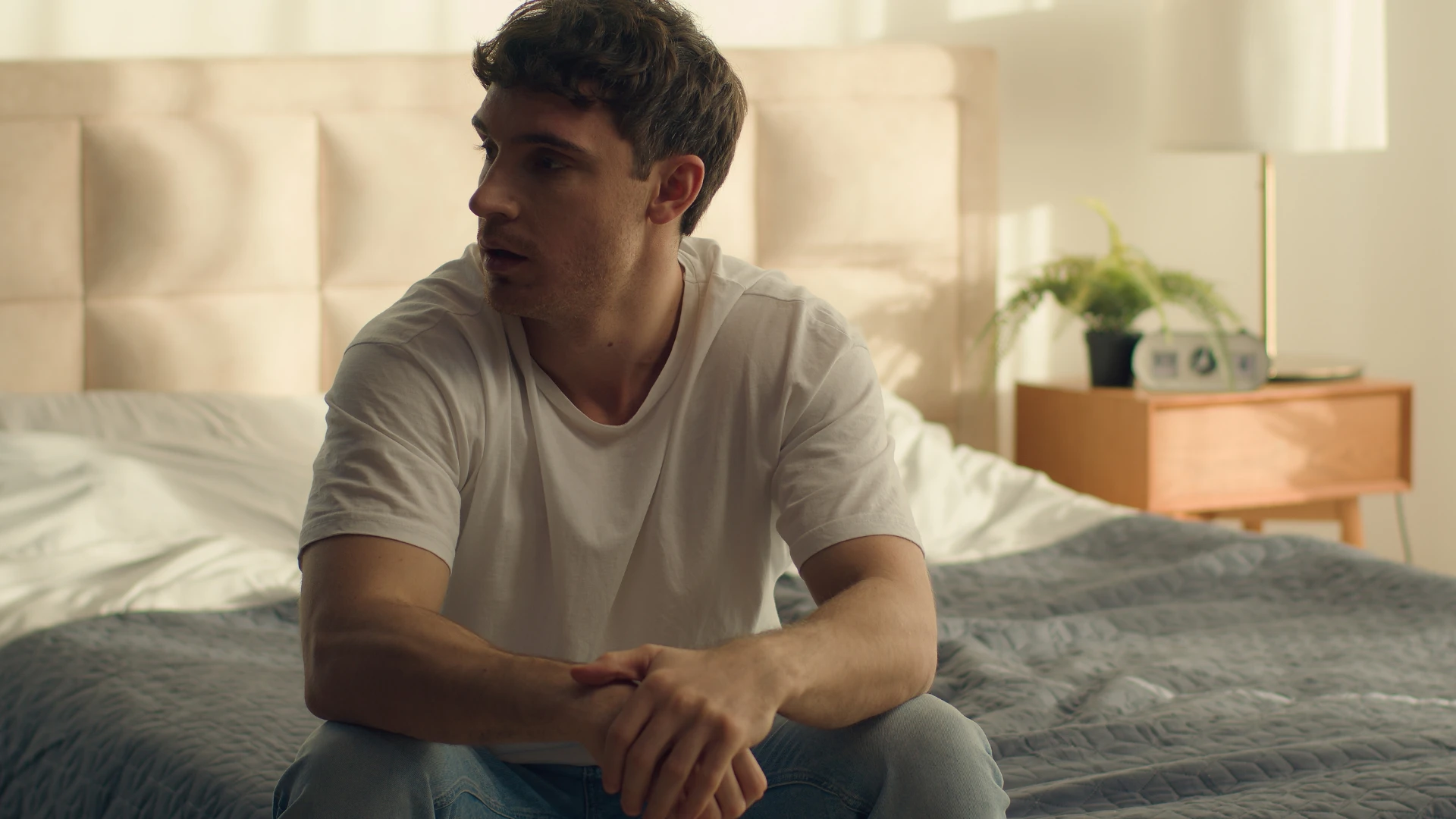 homme honteux assis dans son lit évitant de passer du temps de qualité avec son partenaire