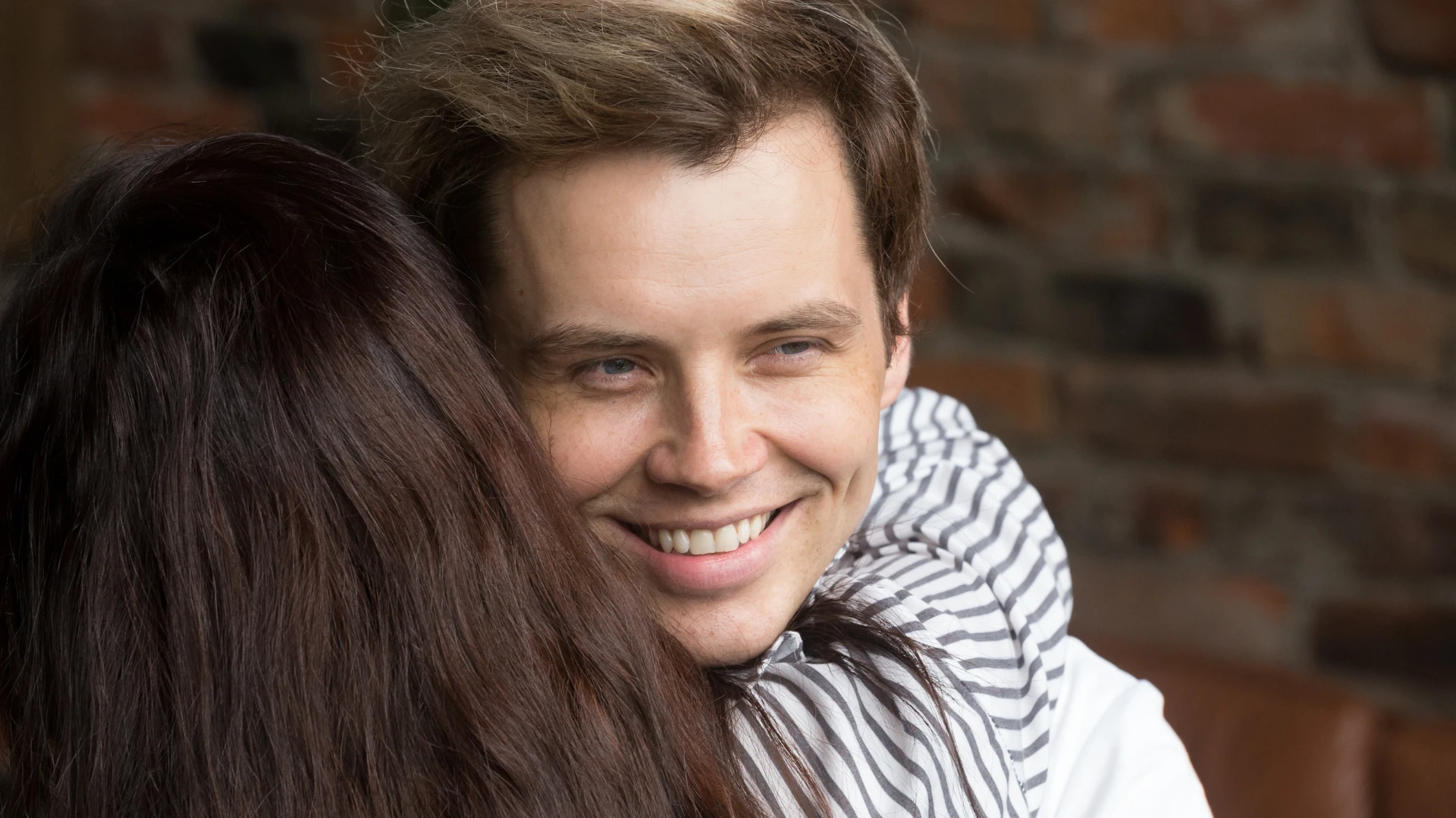 homme forçant à sourire tout en étreignant une femme