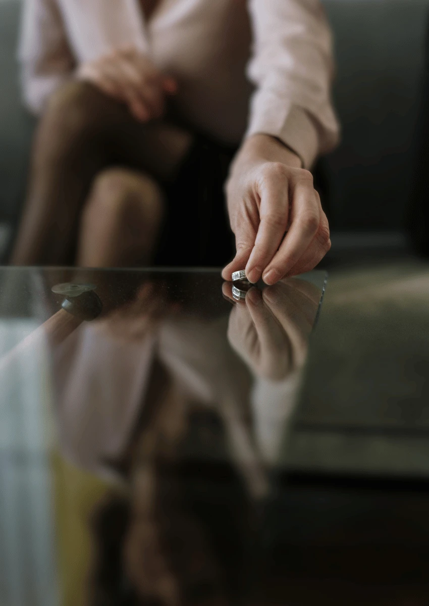 Femme fixant l'alliance sur une table en verre