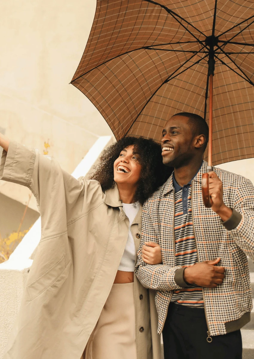 couple heureux, debout, ensemble, sous, parapluie