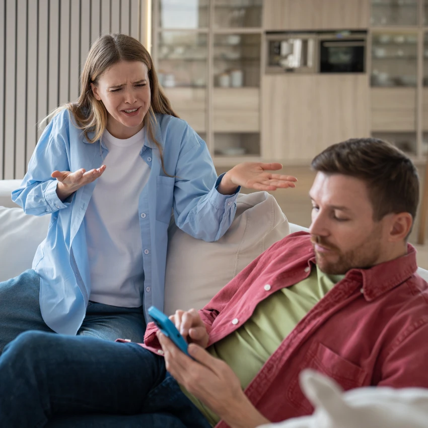 Femme criant après son mari qui ne contribue pas aux tâches ménagères.
