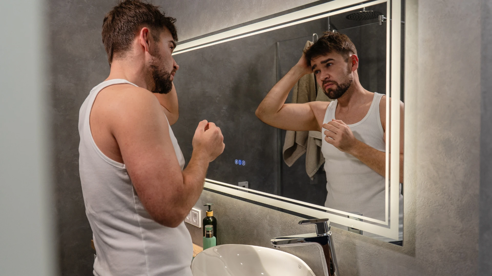 homme se regardant dans le miroir de la salle de bain