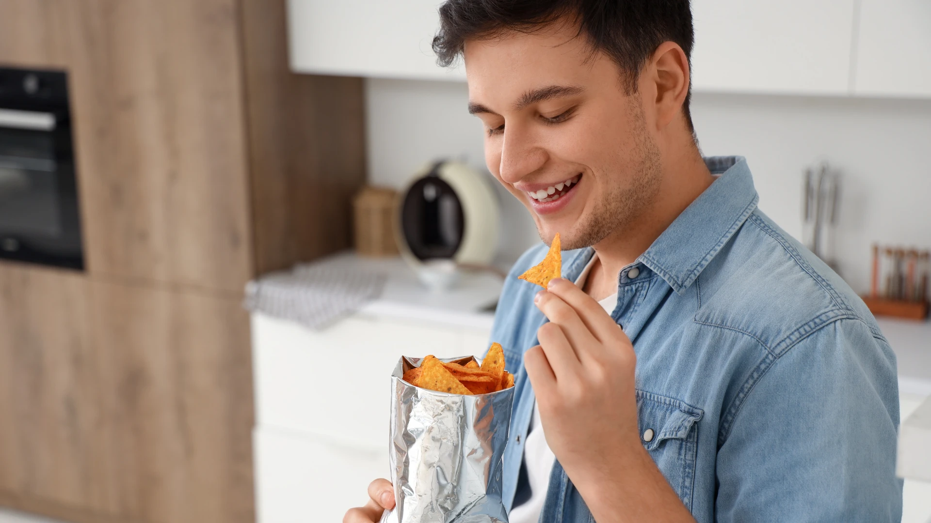 homme grignotant dans la cuisine