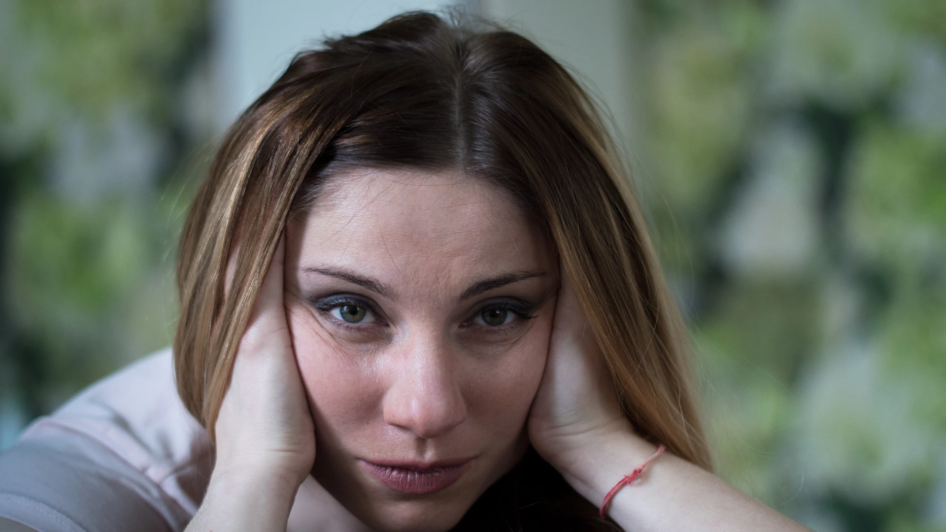 Une femme autodestructrice tient les deux côtés de la tête, montrant un trait qui n'a jamais attiré les hommes
