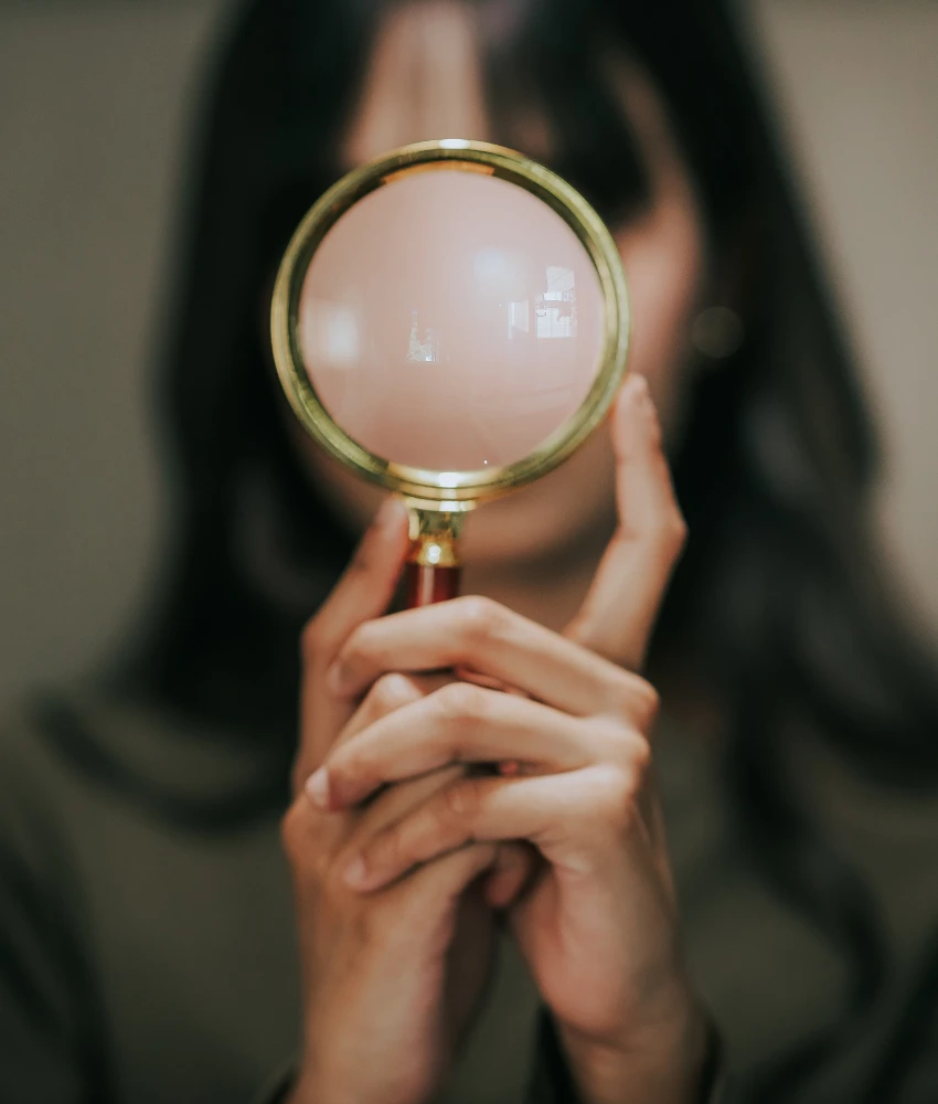 Personne analytique avec une loupe montrant une réflexion excessive pour trouver un sens caché