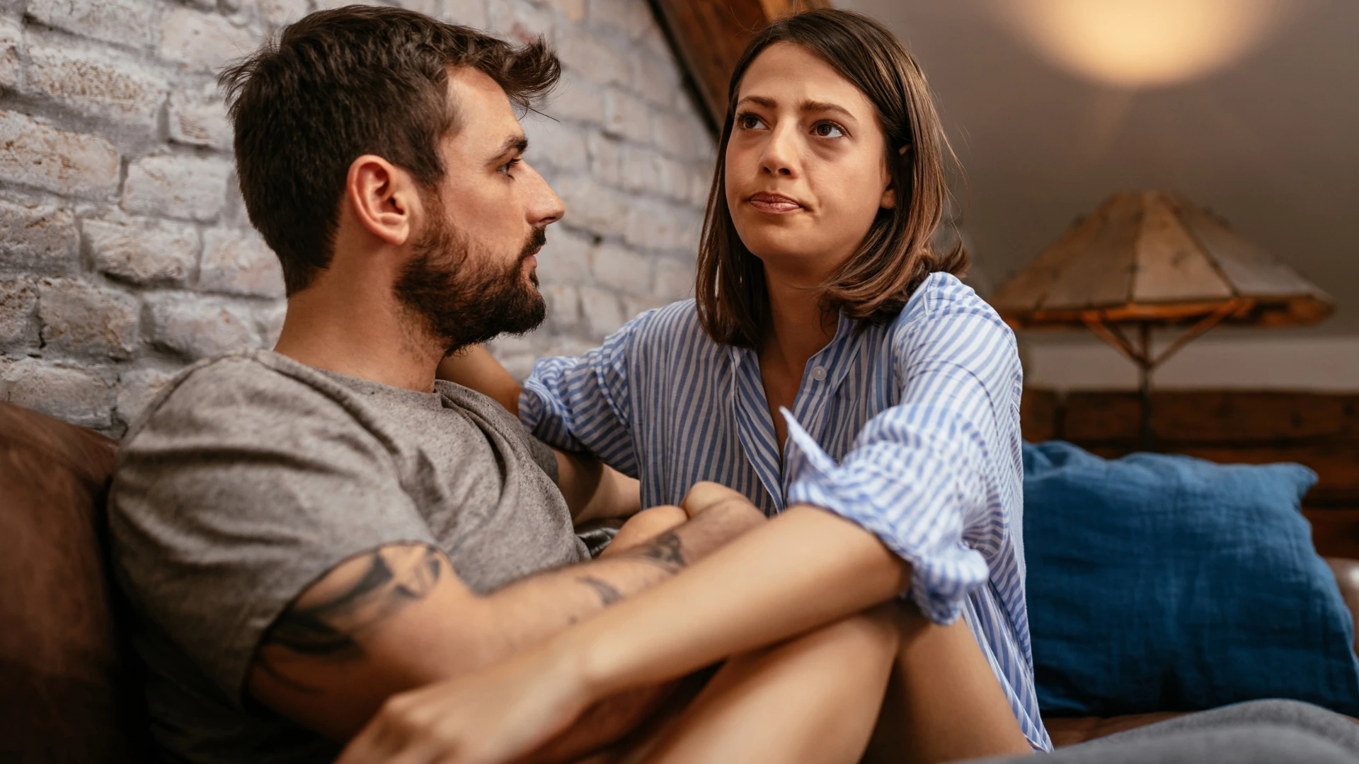 Un homme qui s'excuse sincèrement assis avec sa femme.