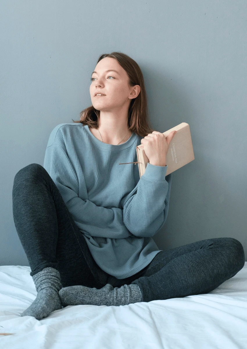 jeune femme assise seule sur son lit