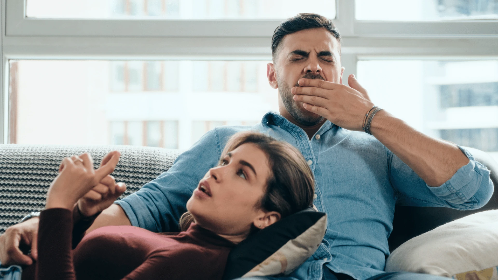 un homme bâille pendant qu'une femme parle