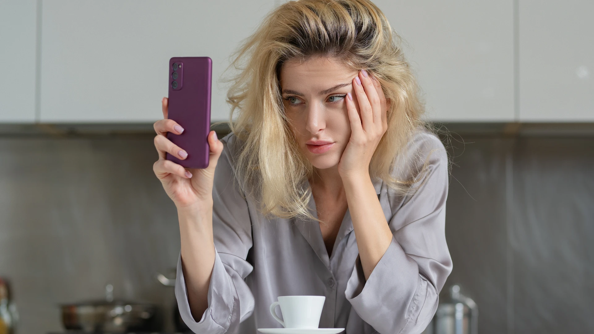 femme qui a l'air fatiguée en regardant son téléphone