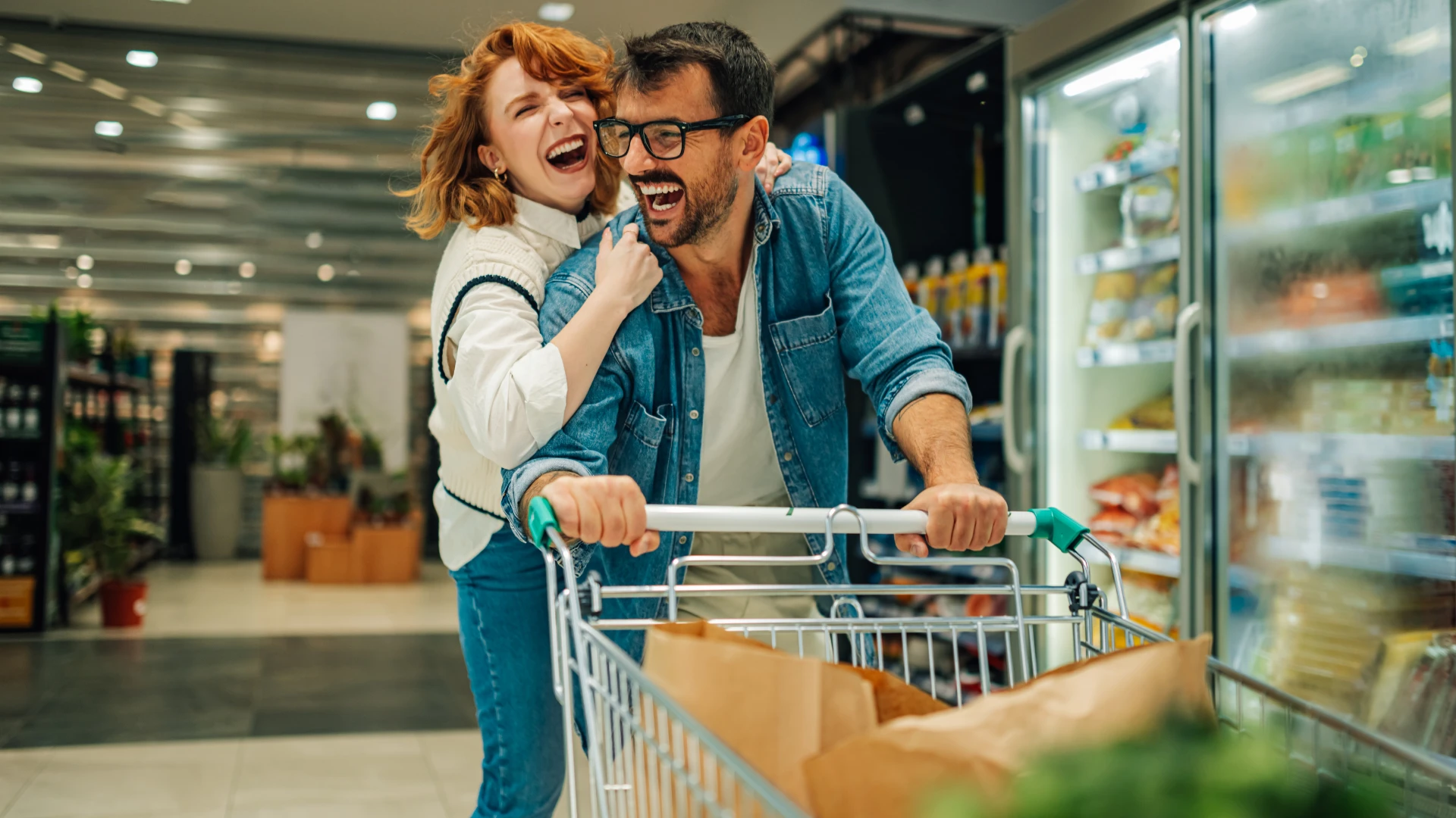 Un couple léger rit en faisant du shopping, montrant un comportement précieux