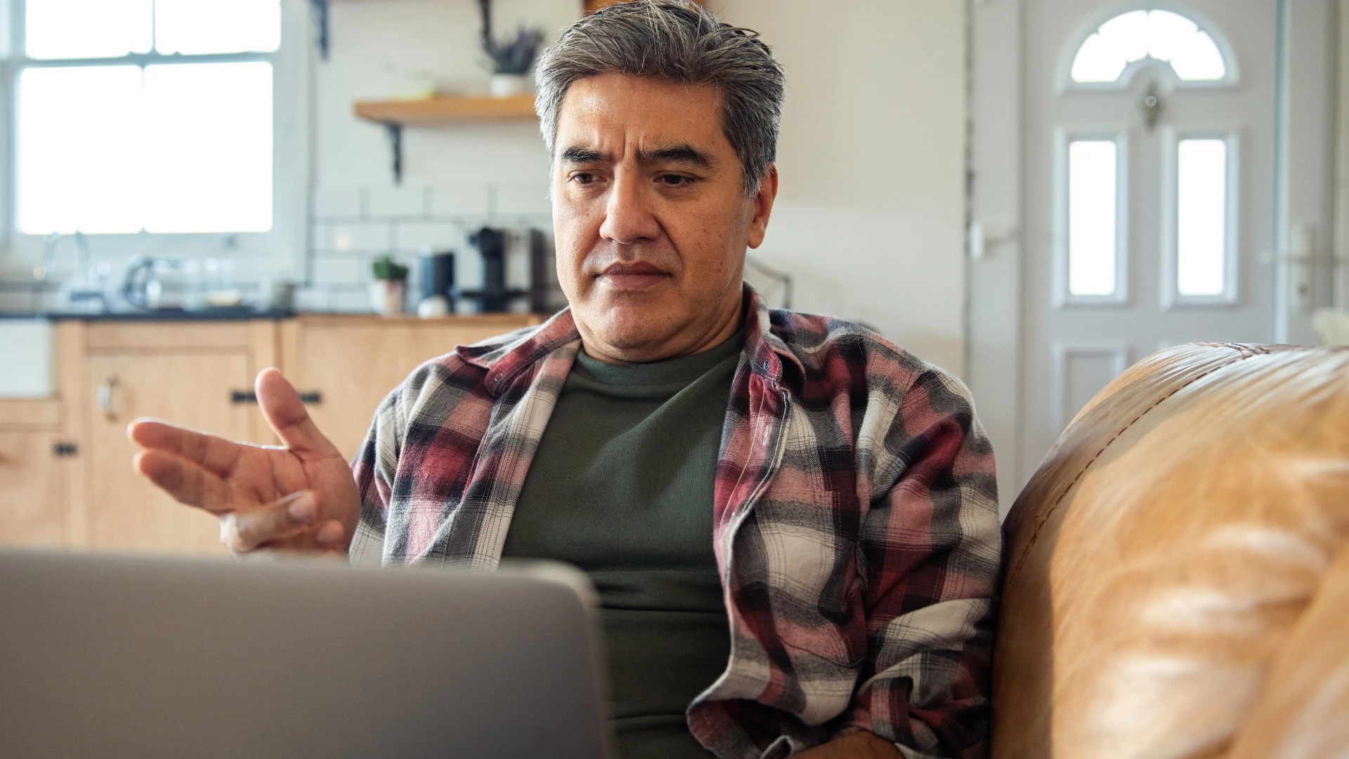 Homme qui se sent à l'aise avec l'inconfort de parler sur son ordinateur portable.