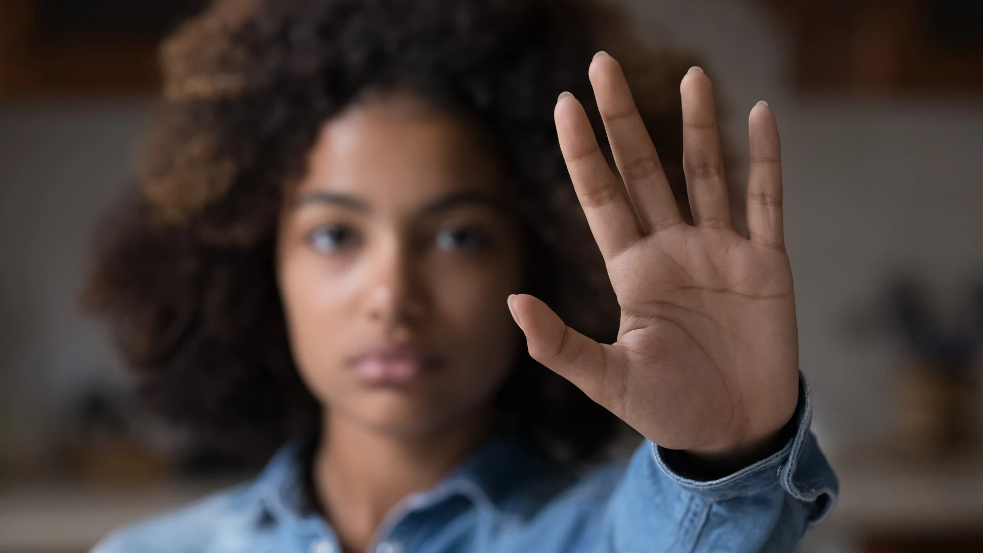 Une femme fermée lève la main pour dire d'arrêter de montrer un trait peu sympathique